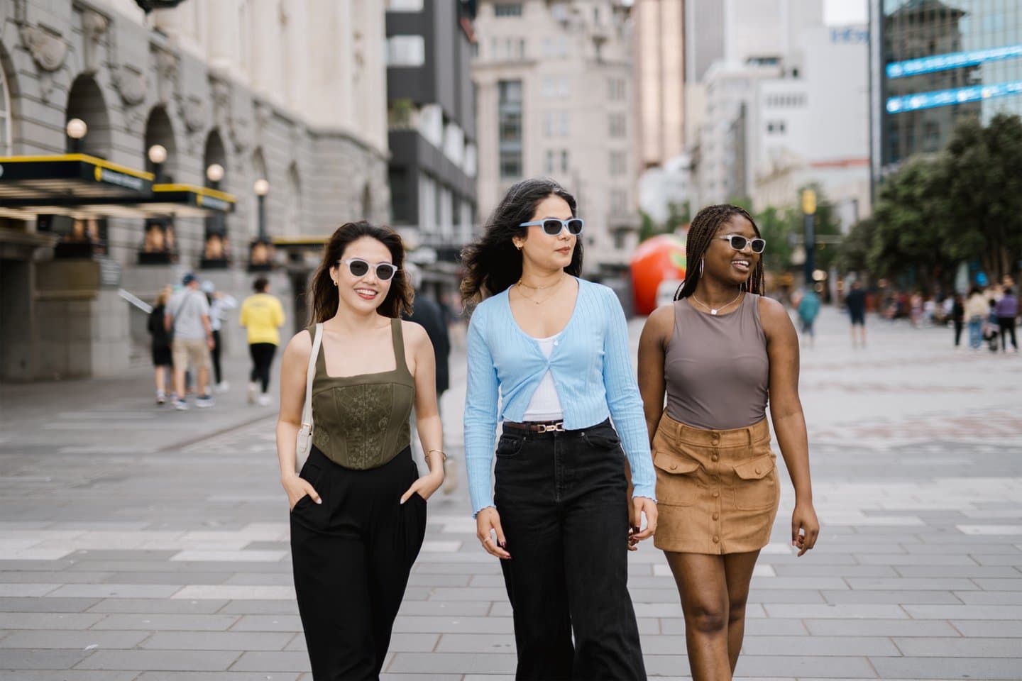 Friends walking outdoors in the city wearing Dresden Vision Canada photochromic sunglasses, offering adaptive UV protection and comfortable vision in changing light conditions.